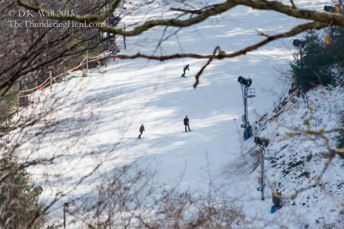 Snowboarders next door enjoying their snow.